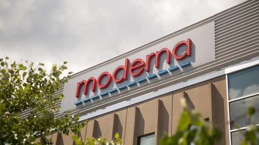 Moderna company name in red lettering on the upper facade of a beige corporate building under a cloudy sky