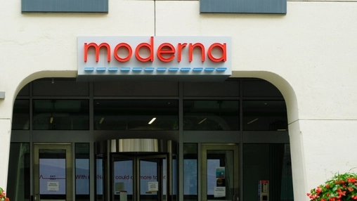 Moderna headquarters building exterior with bold red logo signage mounted above glass entrance doors